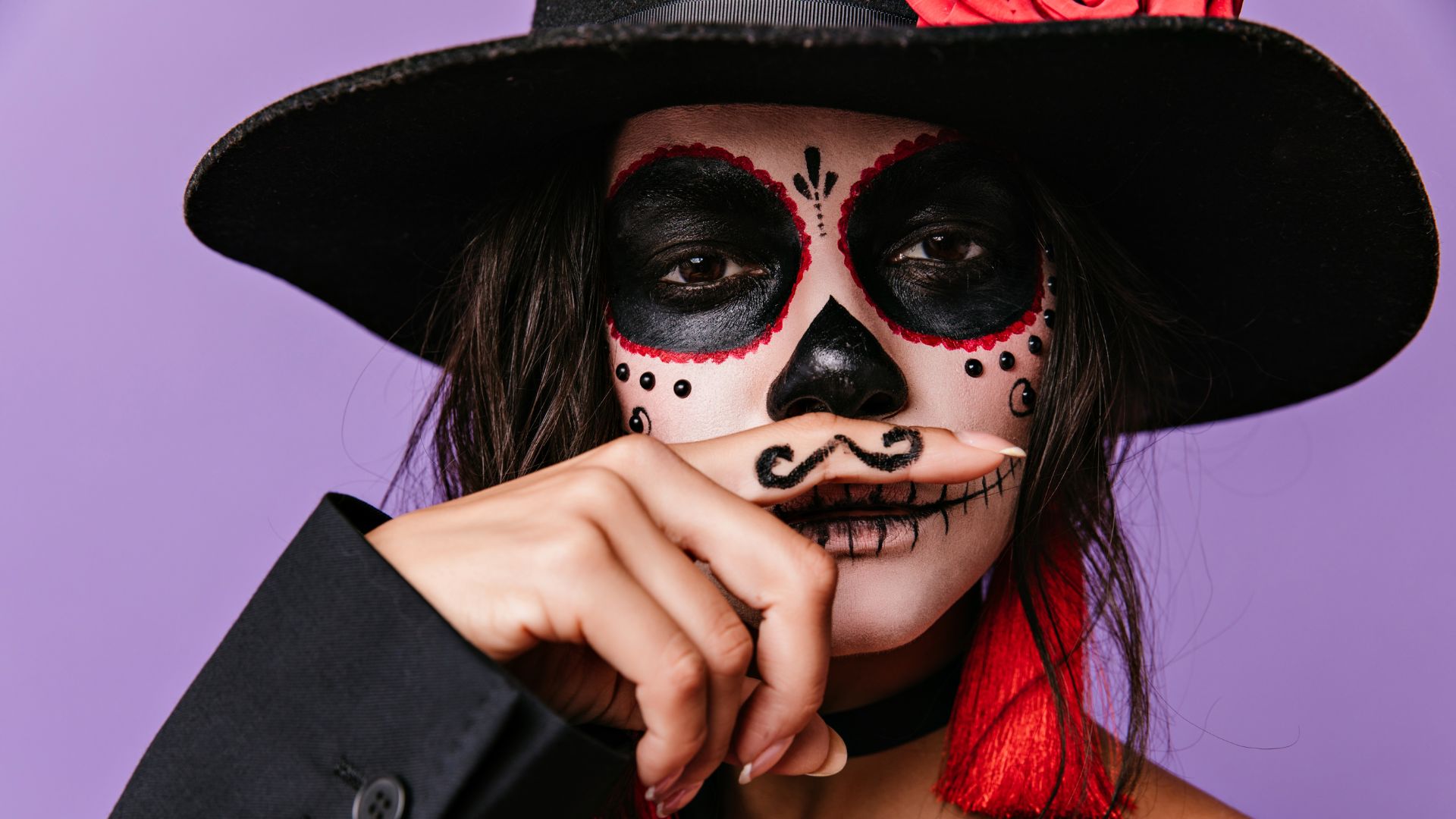 A woman wearing skin-friendly face paint and a moustache, ideal for achieving flawless Halloween makeup.